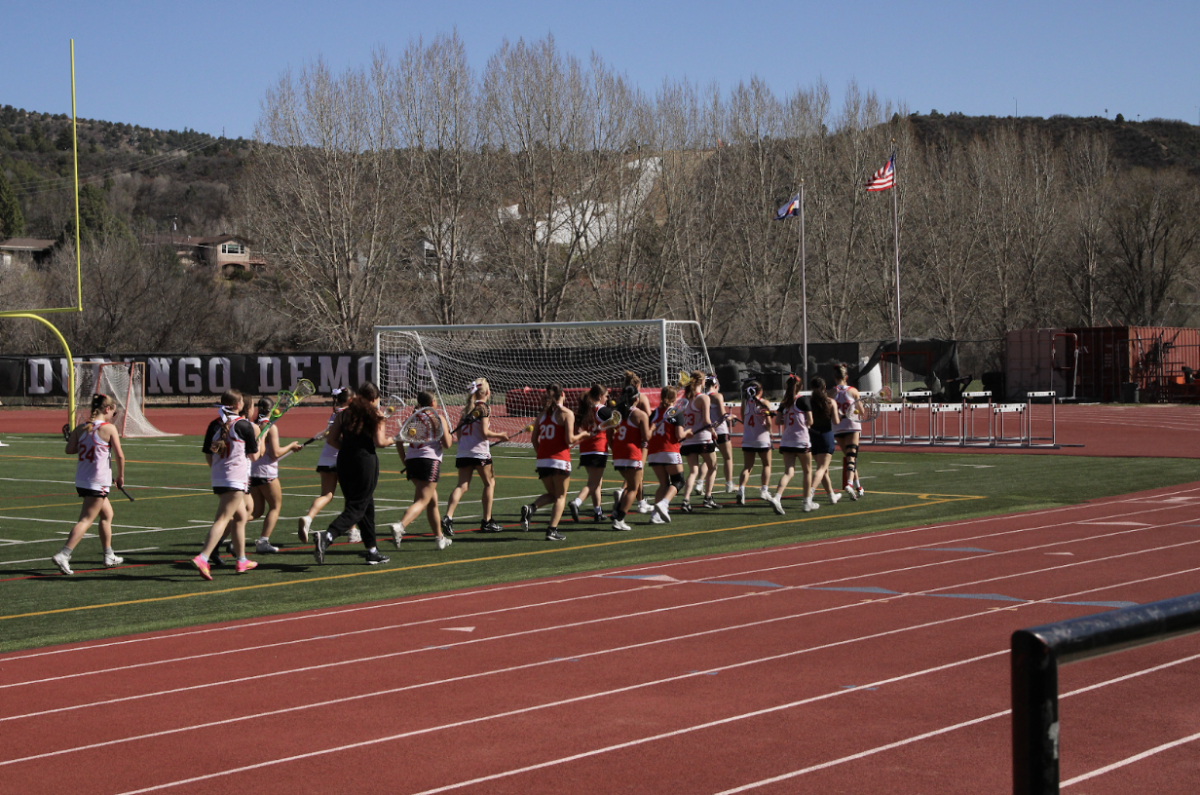 The DHS Girls Lacrosse team warms up with a lap before their game against Fruita Monument on Friday, April 11